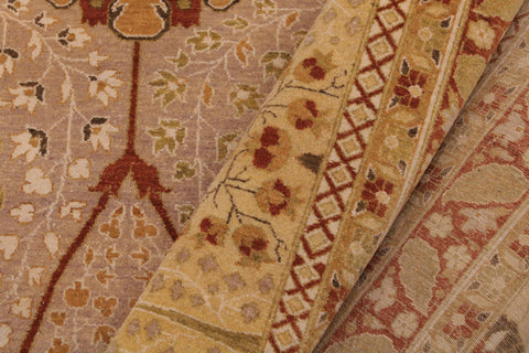 A close-up of a patterned area rug showing its detailed woven texture and traditional motifs in beige, rust red, and muted green.