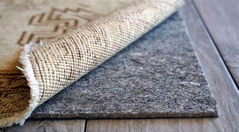 Custom cut heavy duty felt and rubber rug pad, 1/3 inch thick, under a rug on a wood floor